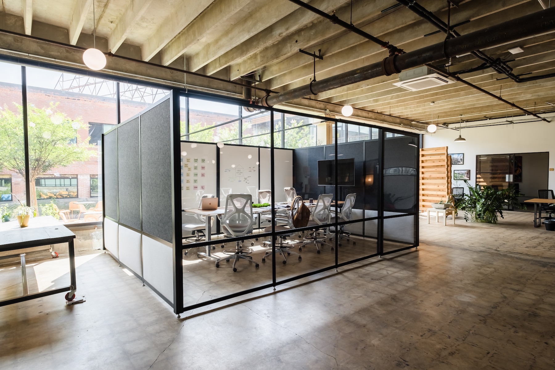 Demountable office meeting room with plexiglass panels, tackable grey panels, writeable dry erase panels and a sliding door