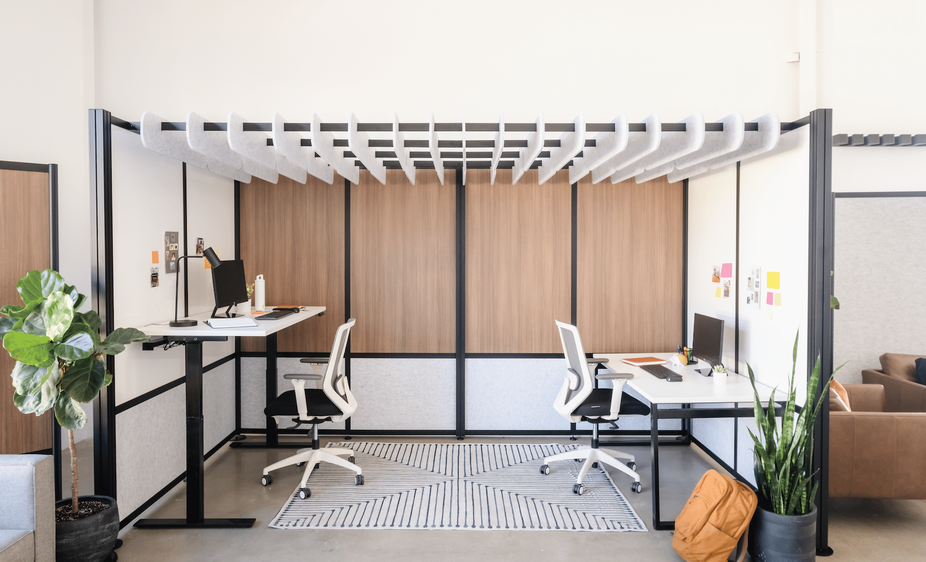 Modern, modular office walls with grey ceiling baffles and 8 walls surrounding 2 employee desks