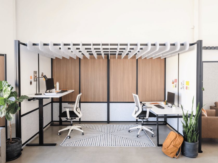 Loftwall Rooms with wood laminate panels and marble ceiling baffles above two office desks