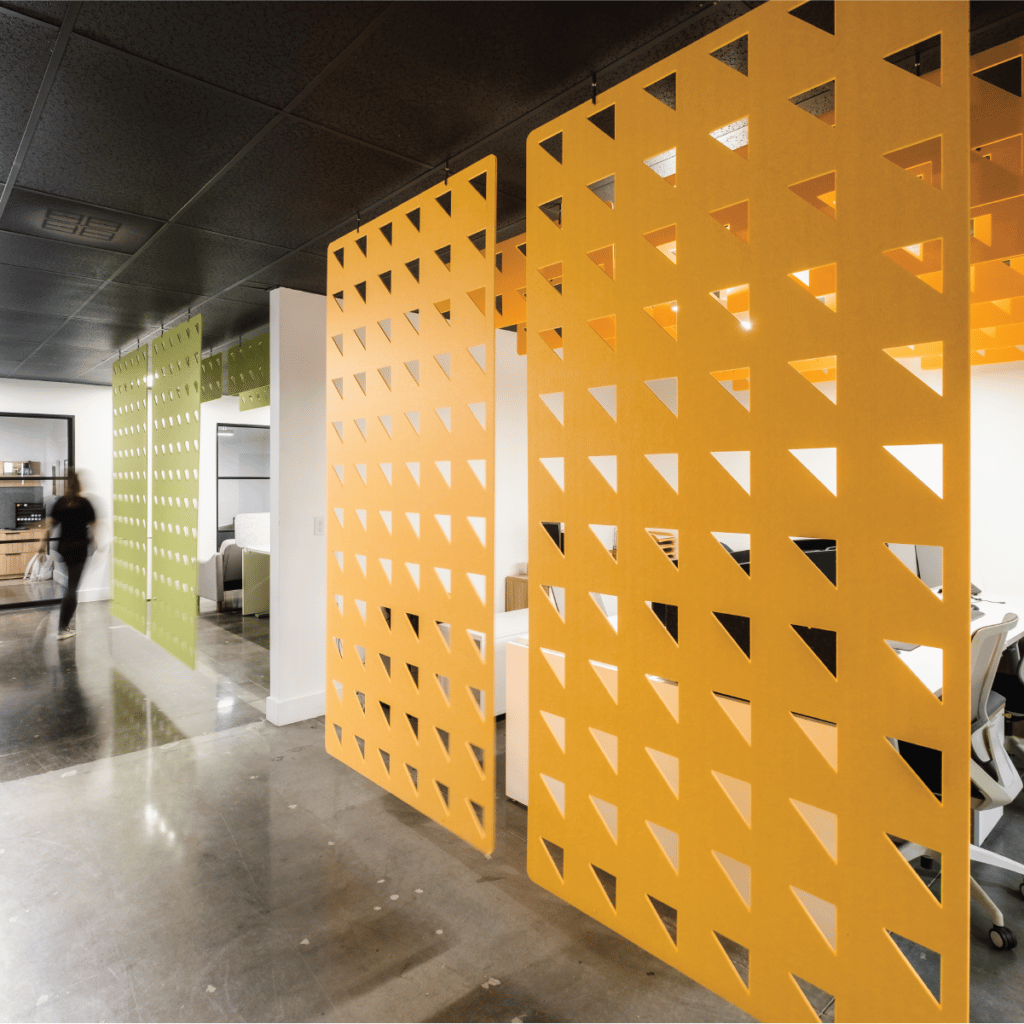 Yellow and green ceiling hung acoustic panels hanging in a modern office