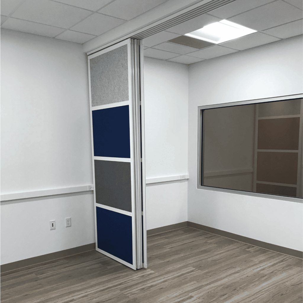 Ceiling mounted room divider Glide hung from a track system with blue and grey panels