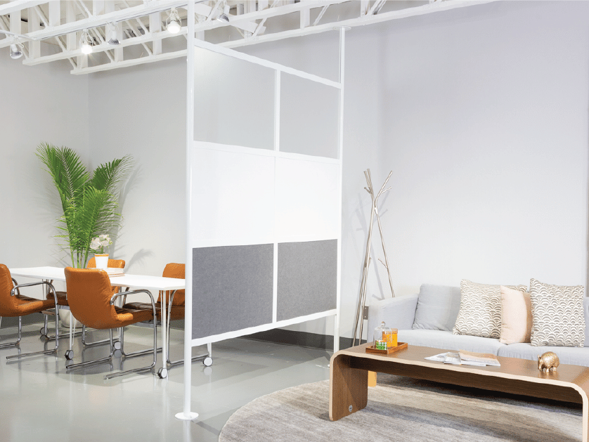 Loftwall Hover ceiling and floor mounted room divider separating a couch from a conference table