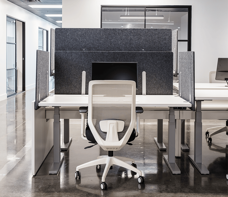 Acoustic felt desk screens in a modern office on a height-adjustable desk